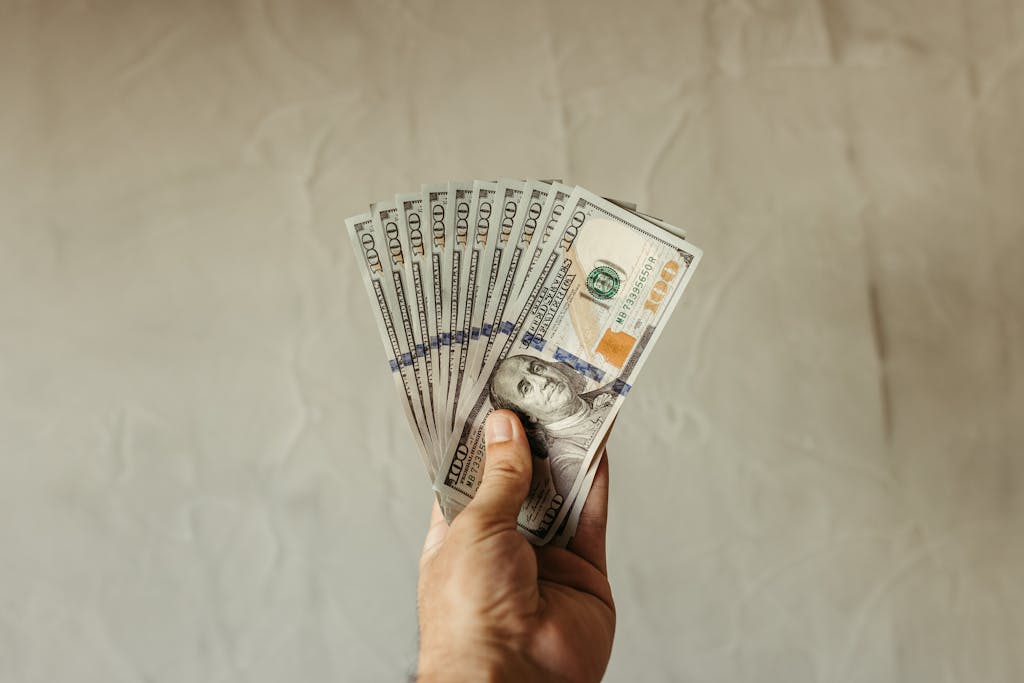 A close-up of a hand holding multiple US dollar bills, showcasing wealth and finance concepts. emergency funds