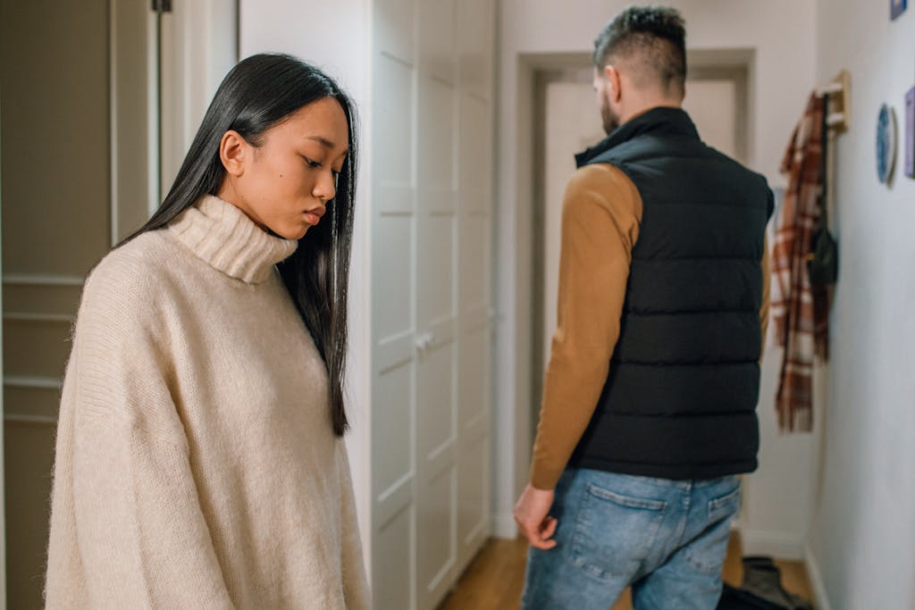 A couple experiencing relationship issues in a hallway, conveying emotional tension. break up