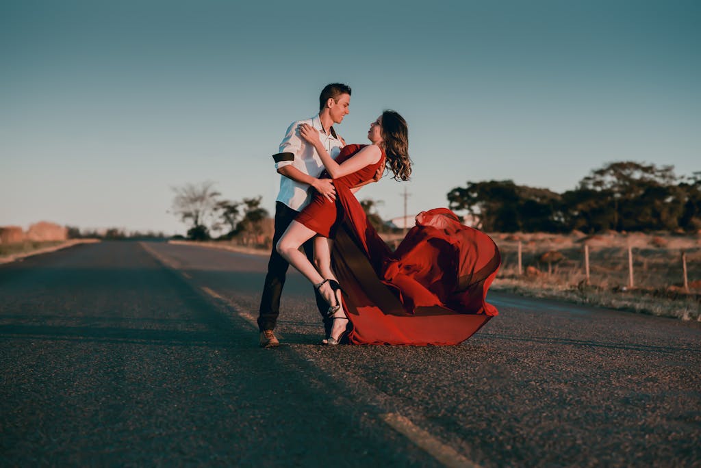 A couple in a passionate dance pose on an empty highway at sunset, showcasing love and romance. sex positivity