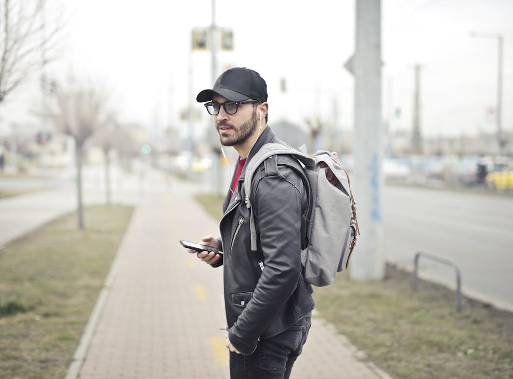 A fashionable young man in Budapest checking his smartphone on a busy street. break up