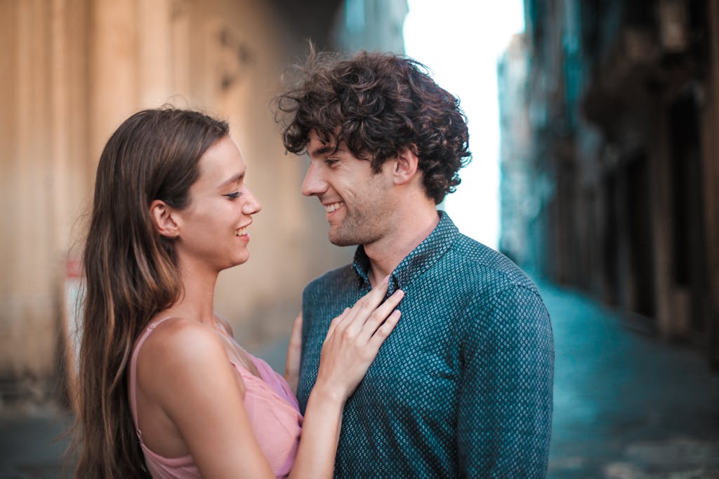 A happy young couple embracing and smiling while enjoying a romantic moment outdoors. flirting techniques