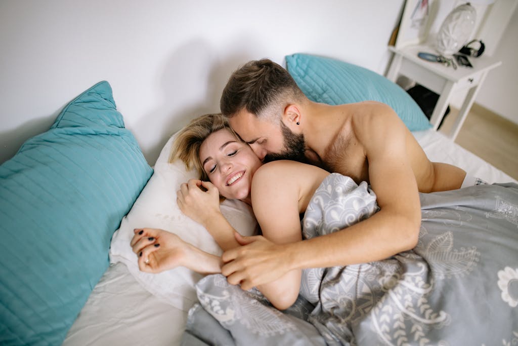 A loving couple shares a tender moment in bed, showcasing affection and warmth. sex positions and best sex position