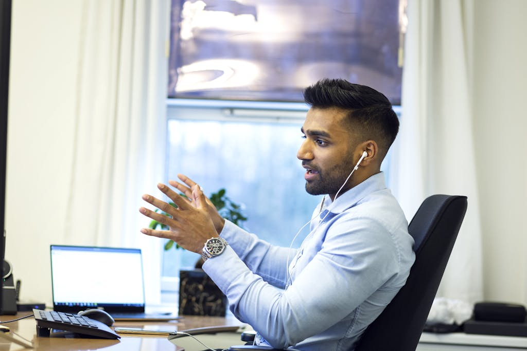 Adult male engaged in a virtual meeting using earphones in an office setting. emotional intelligence and EI skills