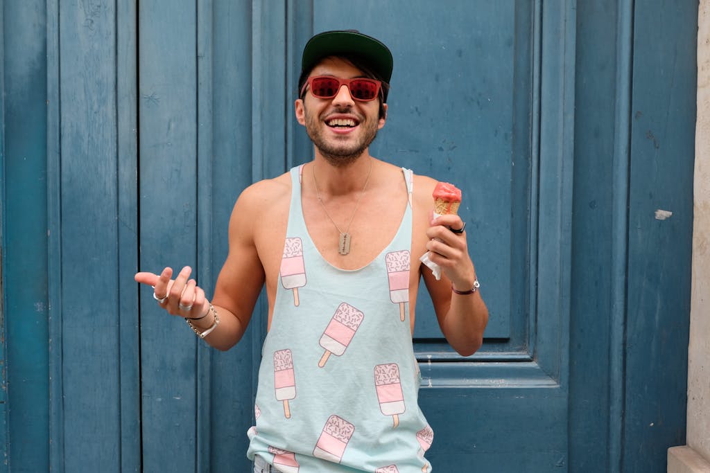 Happy man in Paris enjoying ice cream against a blue door. Fashionable and fun summer vibe. after the first date